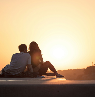 Couple sitting together at sunset