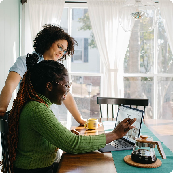 Two women working together on a laptop